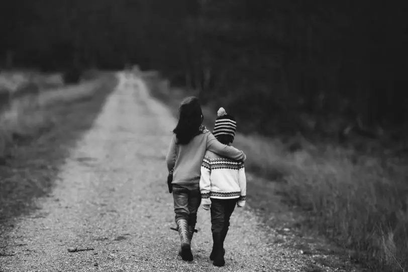 Two kids walking arm in arm like good friends